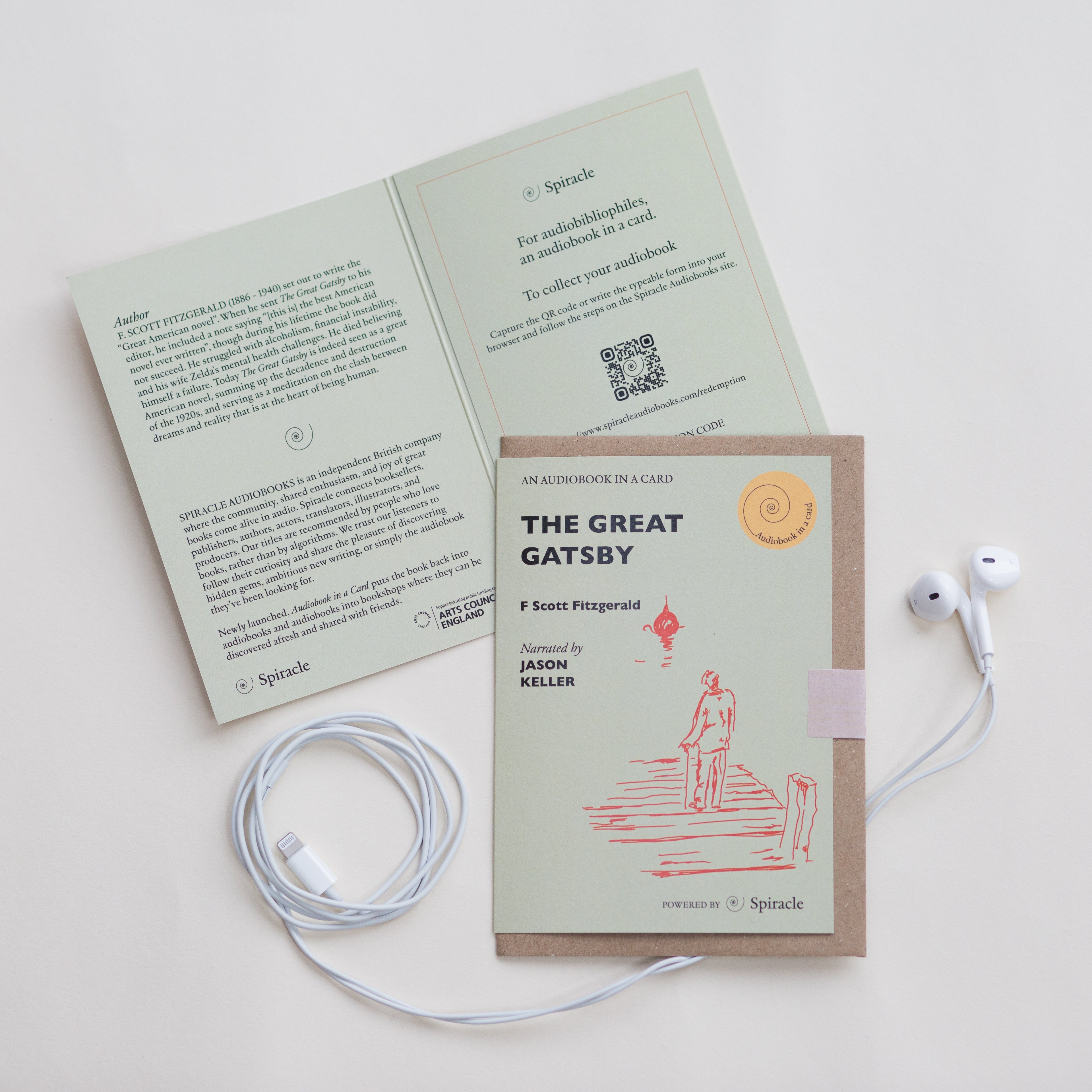 Card with 'The Great Gatsby' cover and earphones on a white background