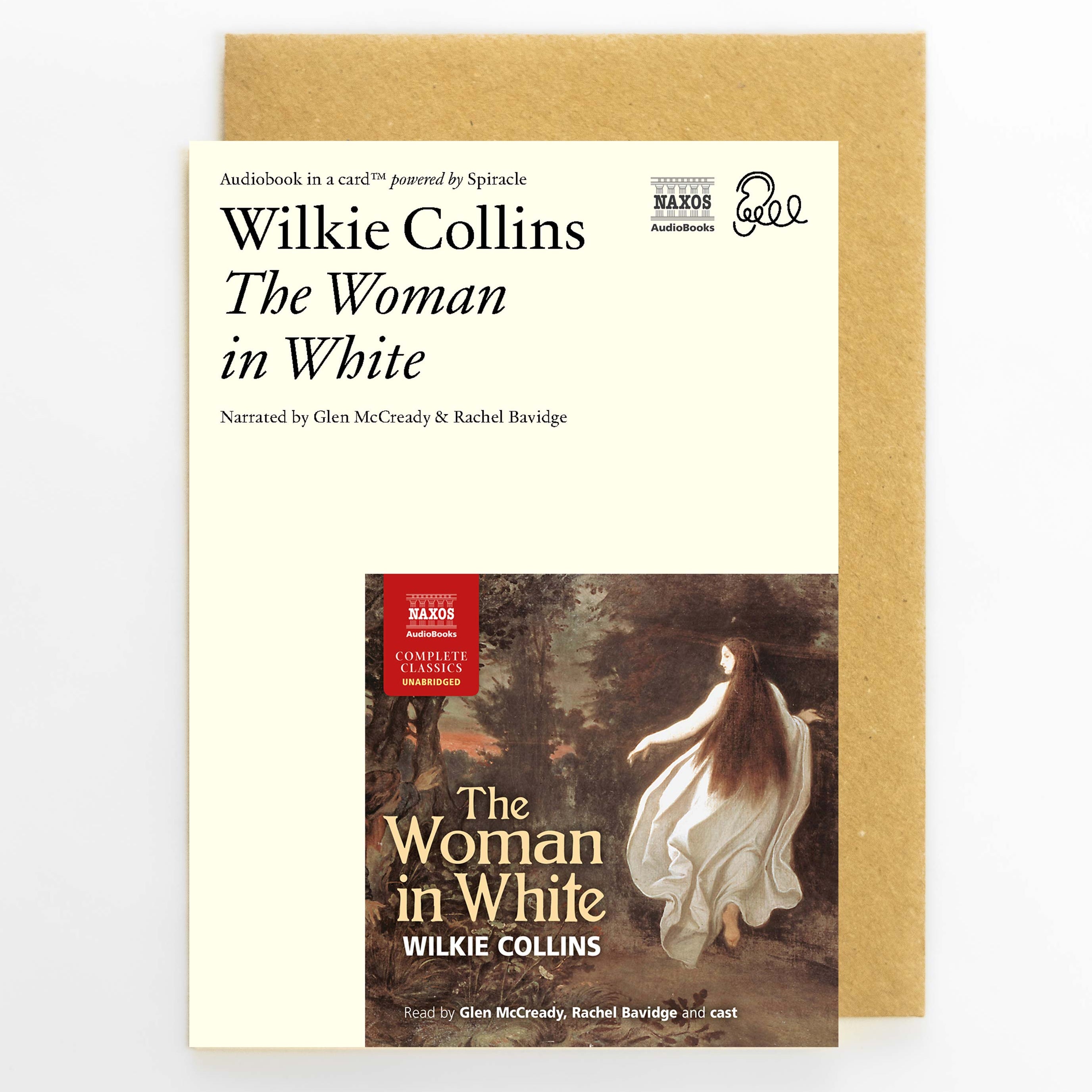 A book cover for 'The Woman in White' by Wilkie Collins, shown in front of a kraft paper envelope on a light gray background. The cover is cream-colored with black text and features a central illustration of a woman in a flowing white dress.