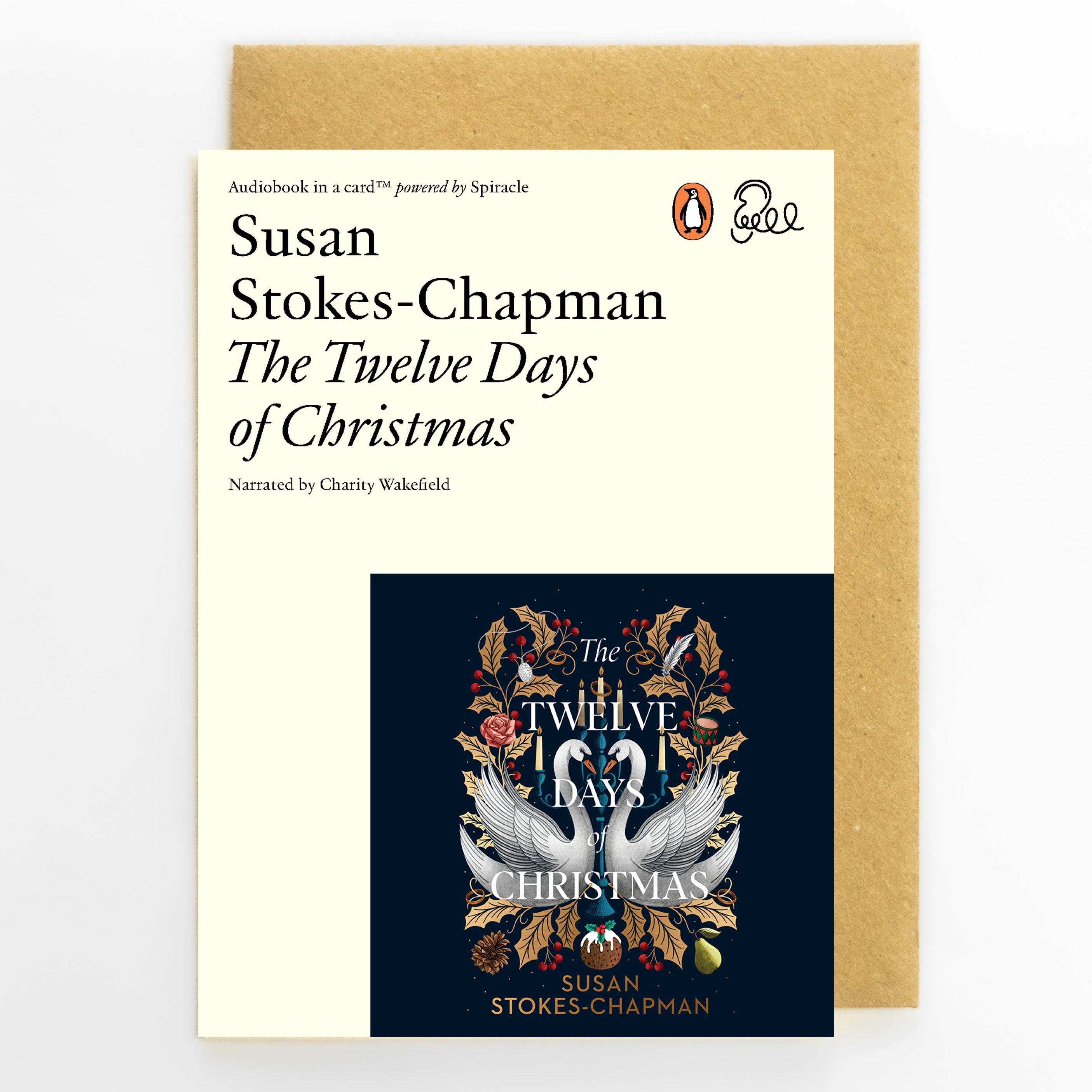 The Twelve Days of Christmas audiobook book cover by Susan Stokes-Chapman, shown in front of its kraft paper envelope on a light gray background. The cover features a cream top half with black text and a dark navy bottom half with a white swan and gold wreath design.