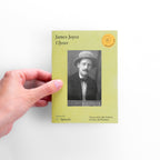 Hand holding a book titled 'Ulysses' by James Joyce on a white background